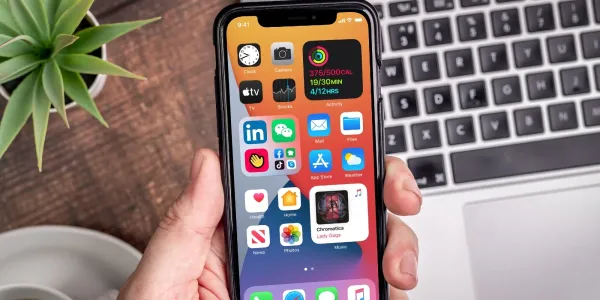 Hand holding iPhone using iOS 14